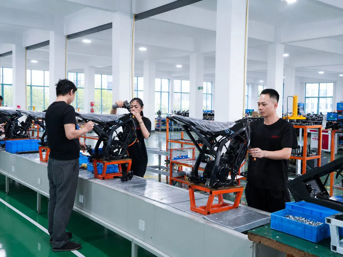 Workers assembling electric dirt bike frames on the final assembly line at the ARKAMOTO plant in Jinhua, China