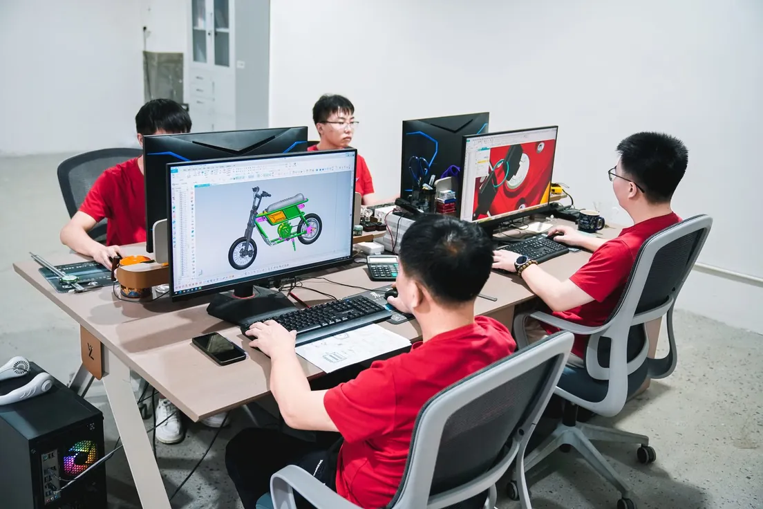 ARKAMOTO engineers working on electric dirt bike designs at CAD workstations